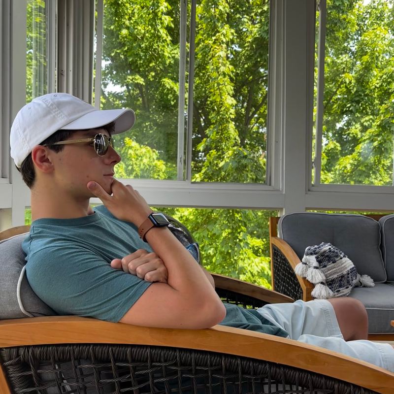 Kyle Guy, founder of Carina Dataworks, in a white cap and sunglasses on a sunny porch